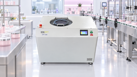 Centrifuge for cosmetics: Spin Tech STP-1500 planetary centrifuge in a bright, pastel-lit personal-care manufacturing cleanroom.